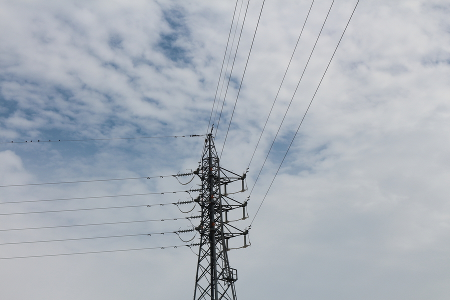 薄雲の広がる秋の空に鉄塔と数本の電線の画像
