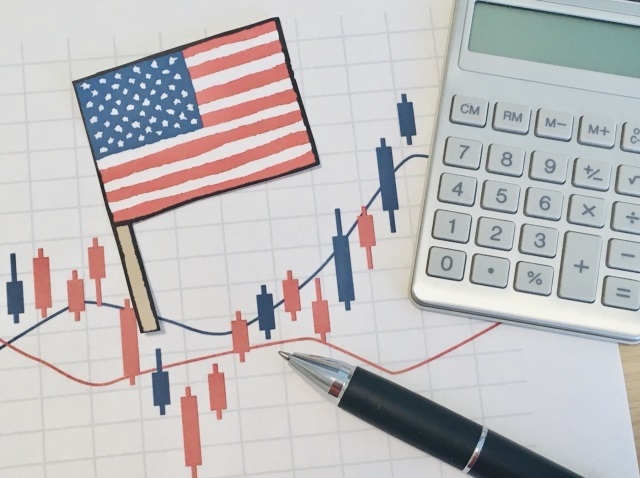株価のチャートとアメリカ国旗と電卓
