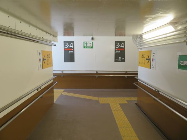 地下通路は壁にペンキを塗っただけのシンプルな内装。左に曲がると階段、右に曲がるとエレベーター。
